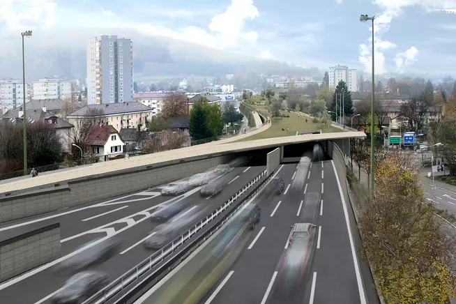 Stadtansicht mit Schnellstrasse, Verkehrsfluss und umgebender Landschaft.