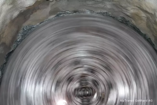 Ein spiralförmiger Tunnel mit reflektierenden Wänden und einem hellen Zentrum.