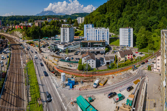 Die K13 führt entlang der SBB Hauptachse über die Überführung Fluhmühle. Im Hintergrund ist die bestehende Felssicherung Stollbergrain zu sehen, rechts das Gleis Richtung Littau. Blickrichtung Luzern (Aufnahme vom 11.06.2021).